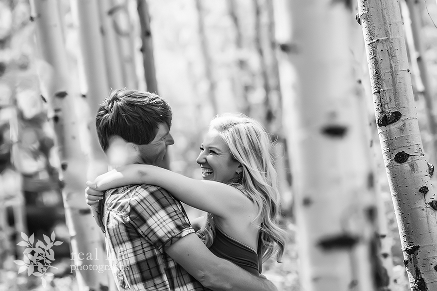 Ouray couple playfully loving in the aspen grove at their engagement session