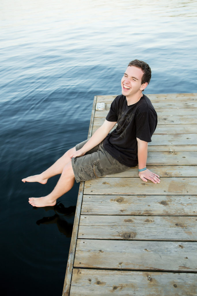 real life photographs documents this senior boy on his dock outside his home