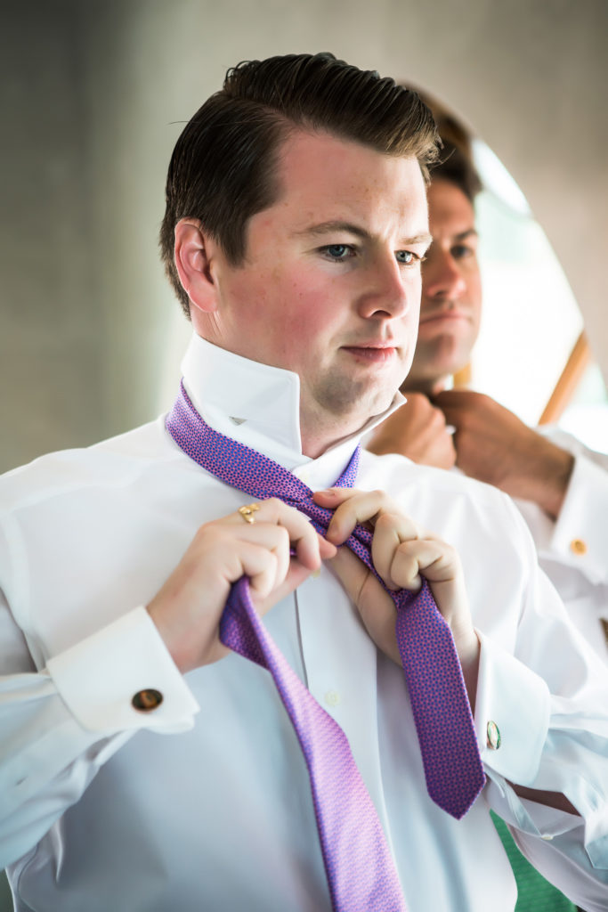 groom putting his tie on, getting ready for his San Sophia Overlook wedding in Telluride, Co