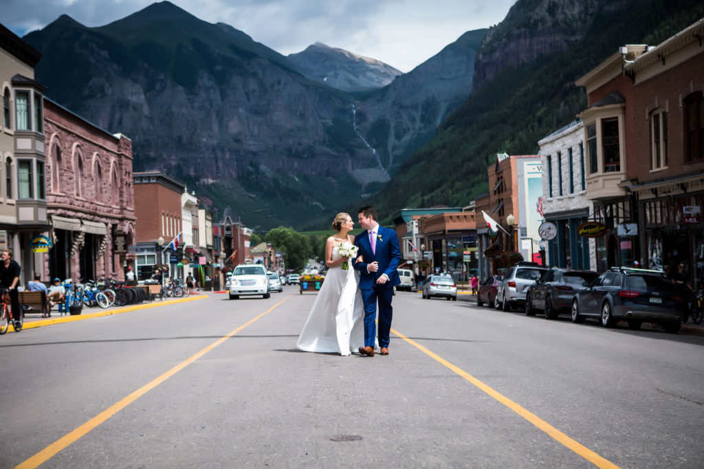 Bride and groom take portraits on their Telluride wedding day.  Photographed by Telluride wedding photographer Real Life Photographs on main street in Telluride
