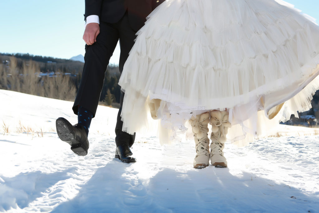 wedding couple displays their wedding shoes in the snow