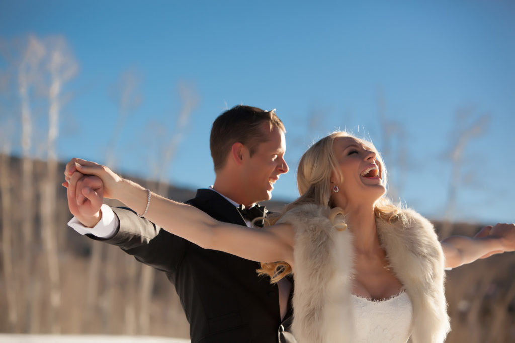 wedding couple tries a Titanic pose in the snow on their wedding day.