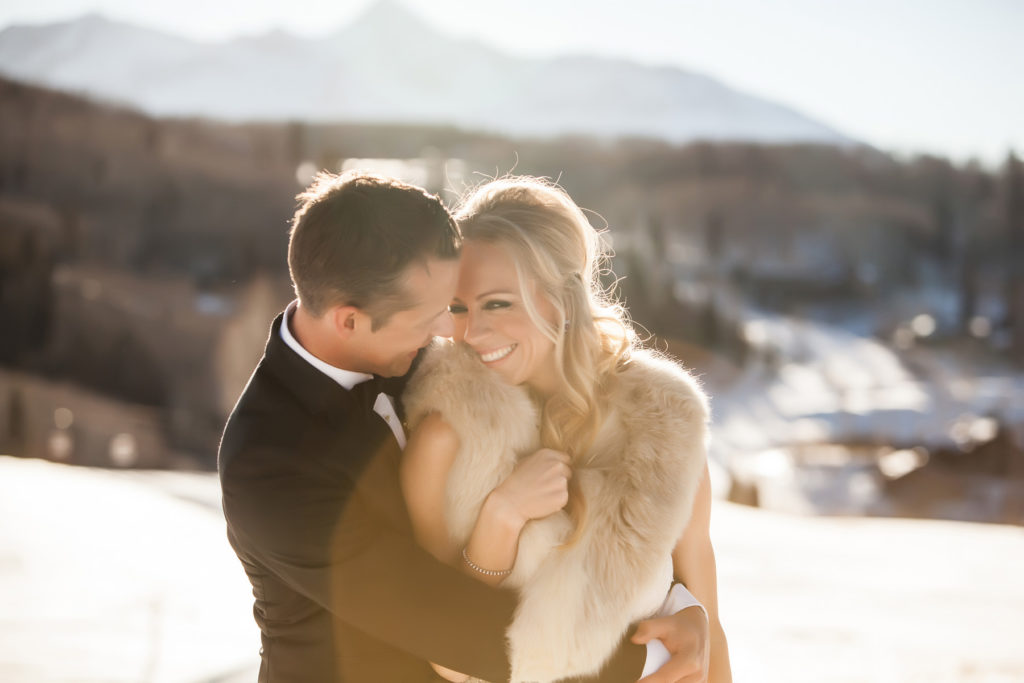 Bride clutches her fur with mount Wilson in the background.