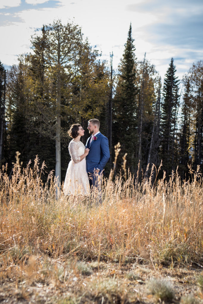 Elopement couple gazes into each others eyes in the long grass in Telluride, Colorado.