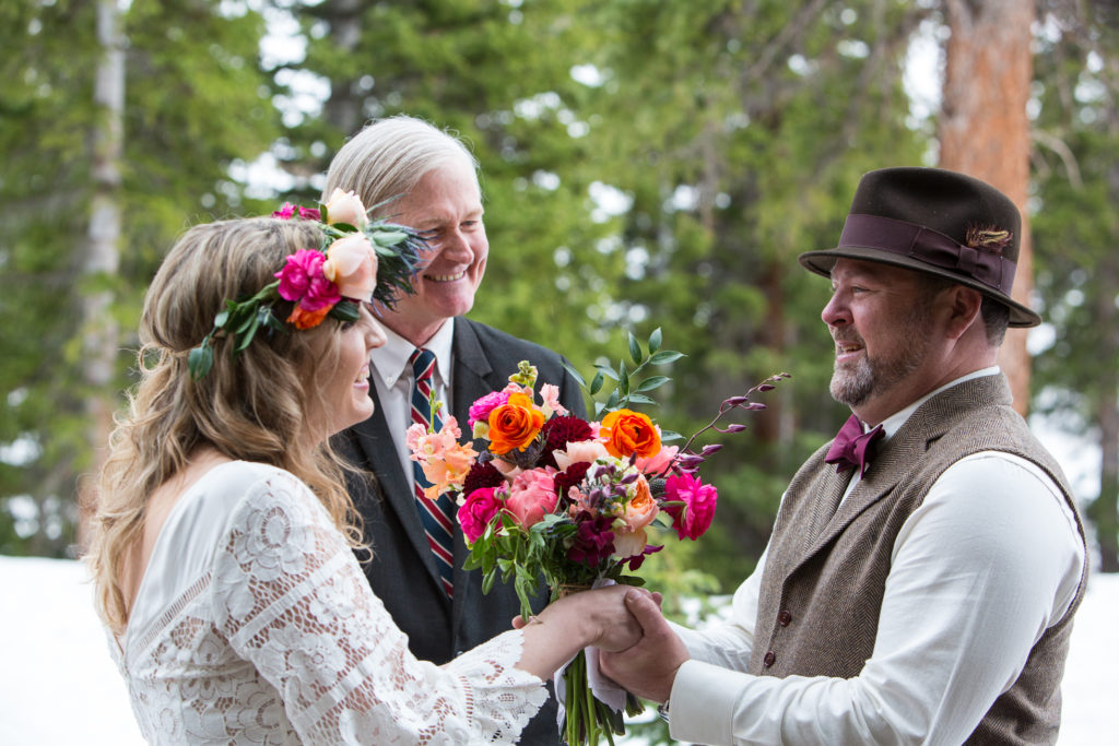 couple exchange their vows in the snow with mountains of Telluride surrounding them