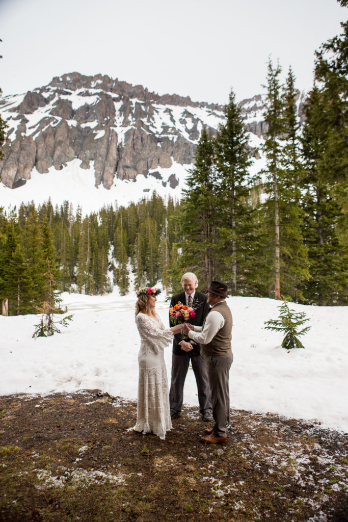 exchanging of wedding rings in Telluride, Colorado with the mountains of the Observatory surrounding them