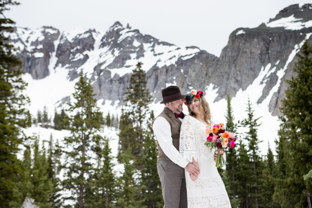 boho bride and groom In the snow at Telluride's Observatory at Alta Lakes