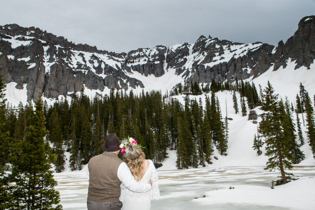 boho bride and groom In the snow at Telluride's Observatory at Alta Lakes