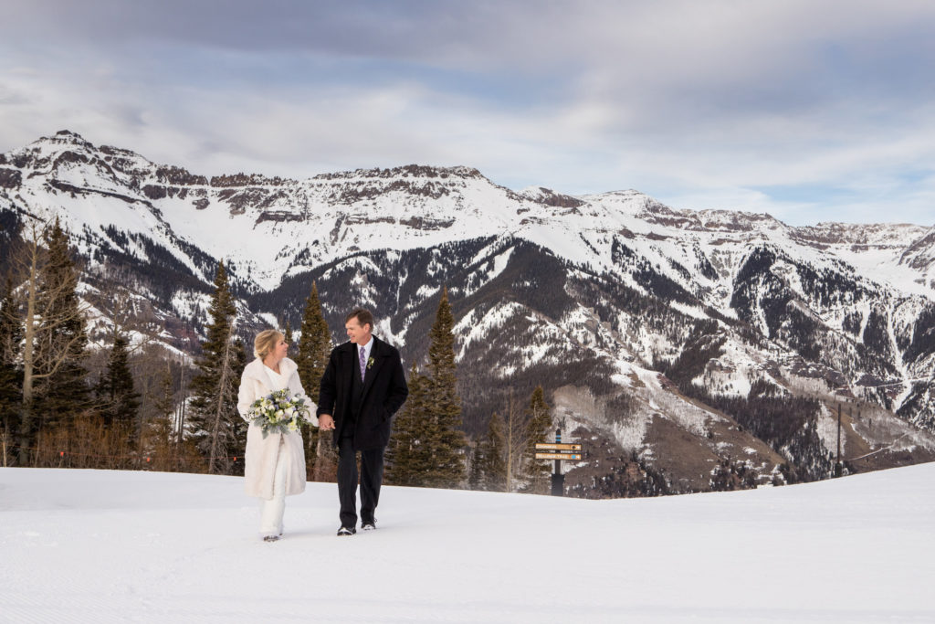 Couple walks in the snow on top of the ski area 