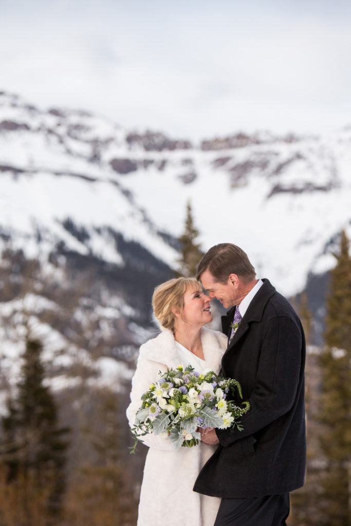 Couple takes a moment to take it all in, while standing on the snow on top of the ski area 