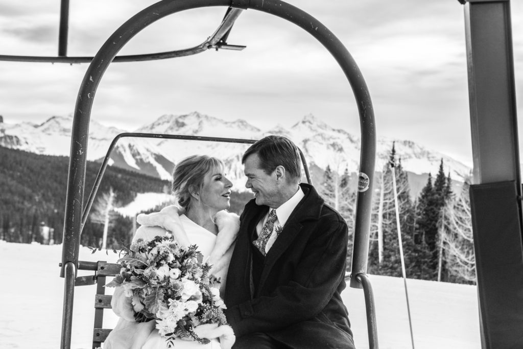 couple poses on the chairlift during their winter elopement on the Telluride ski area