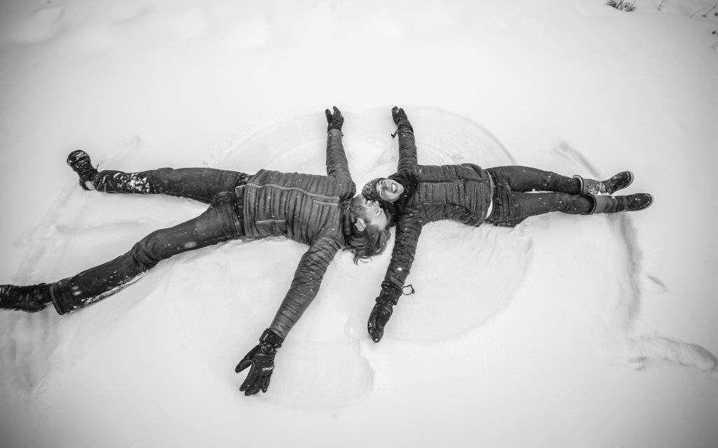 snow angels during an engagement session in Telluride, Co.  Create natural looking engagement photos