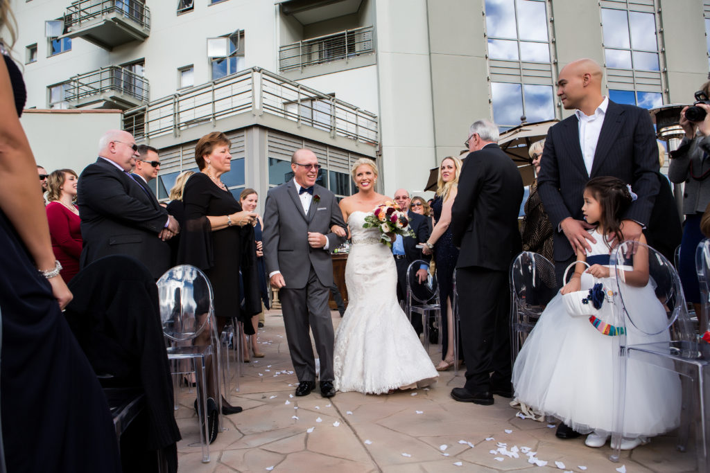 Father of the bride and bride walk down the aisle on the Altezza Deck at the Peaks Hotel