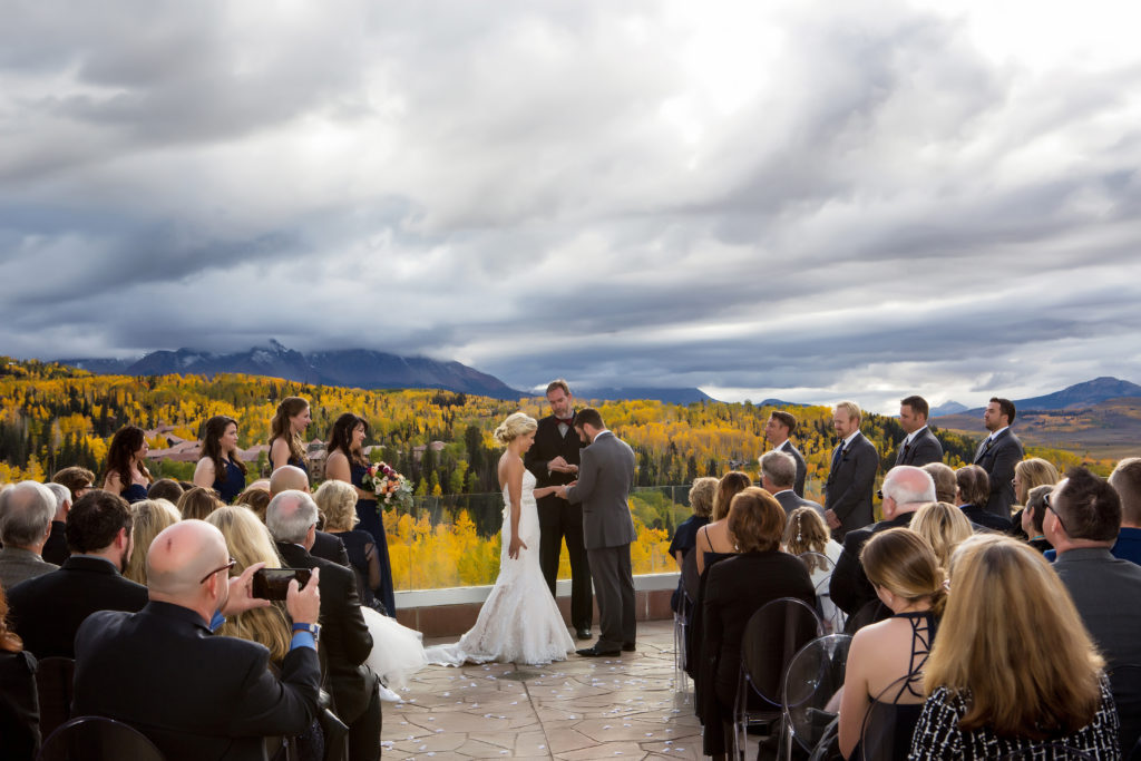 a wedding couple shares wedding rings on the altezza deck at the Peaks hotel in Telluride, Co.