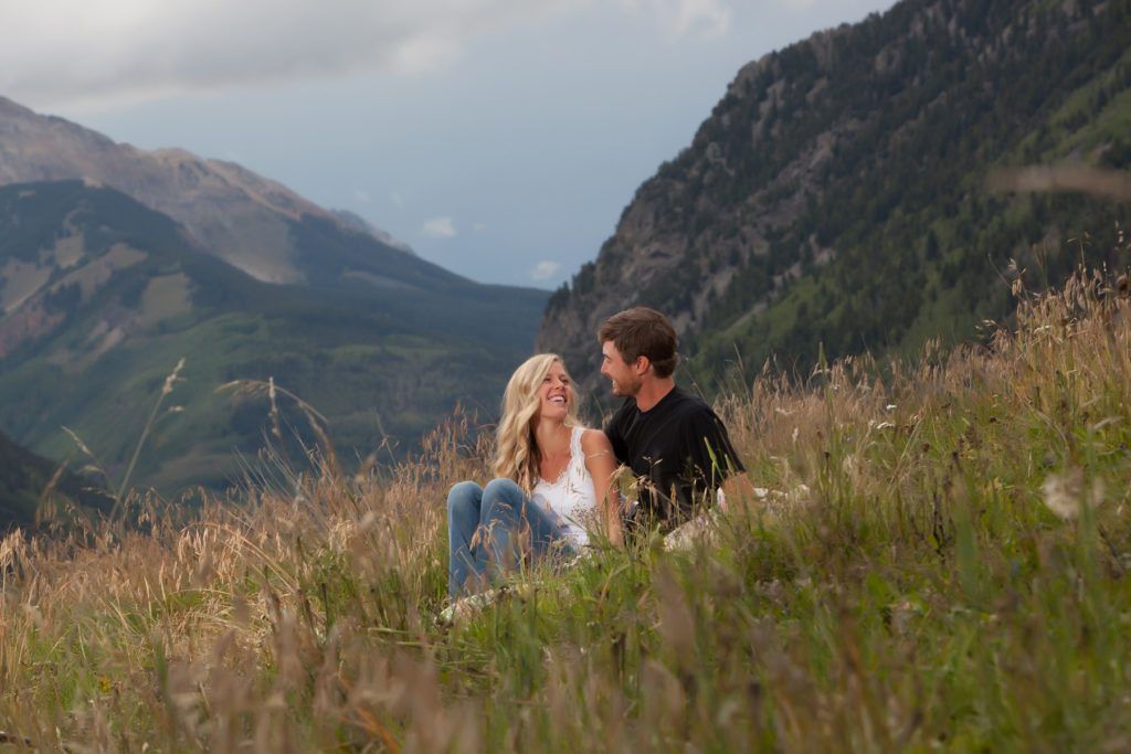 long time telluride locals pose in a field for their engagement session.