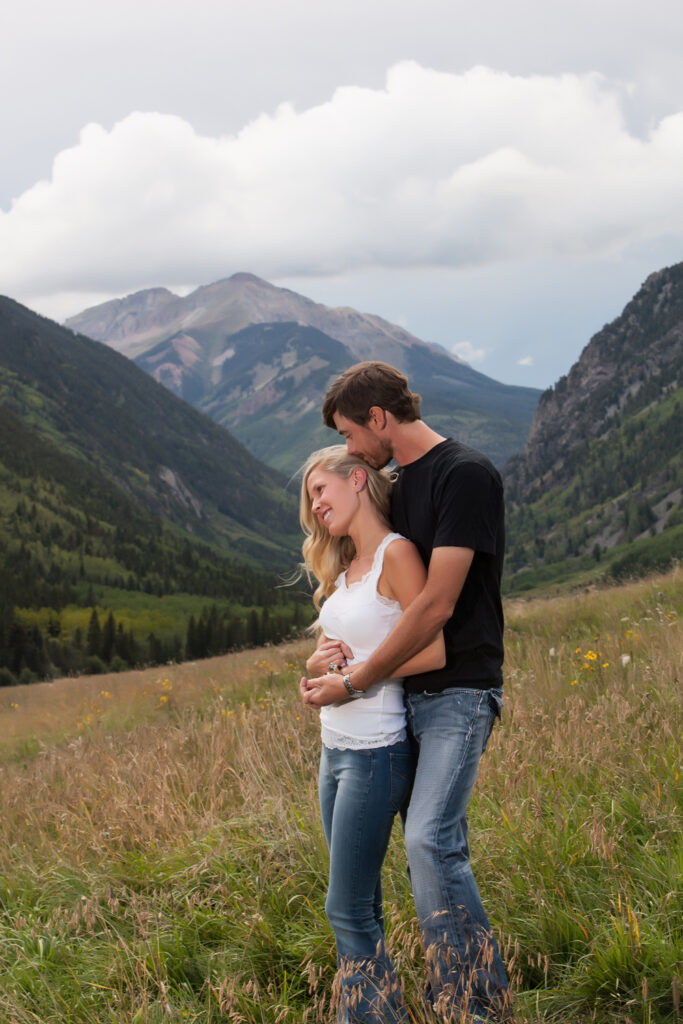 engaged couple snuggles in the mountains of Ophir, Colorado